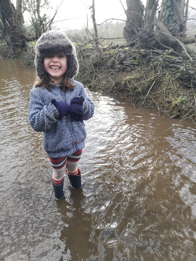 A six year old wading in a huge puddle