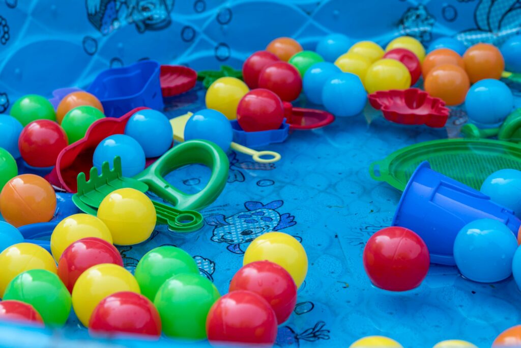 A paddling pool full of colourful plastic balls and toys